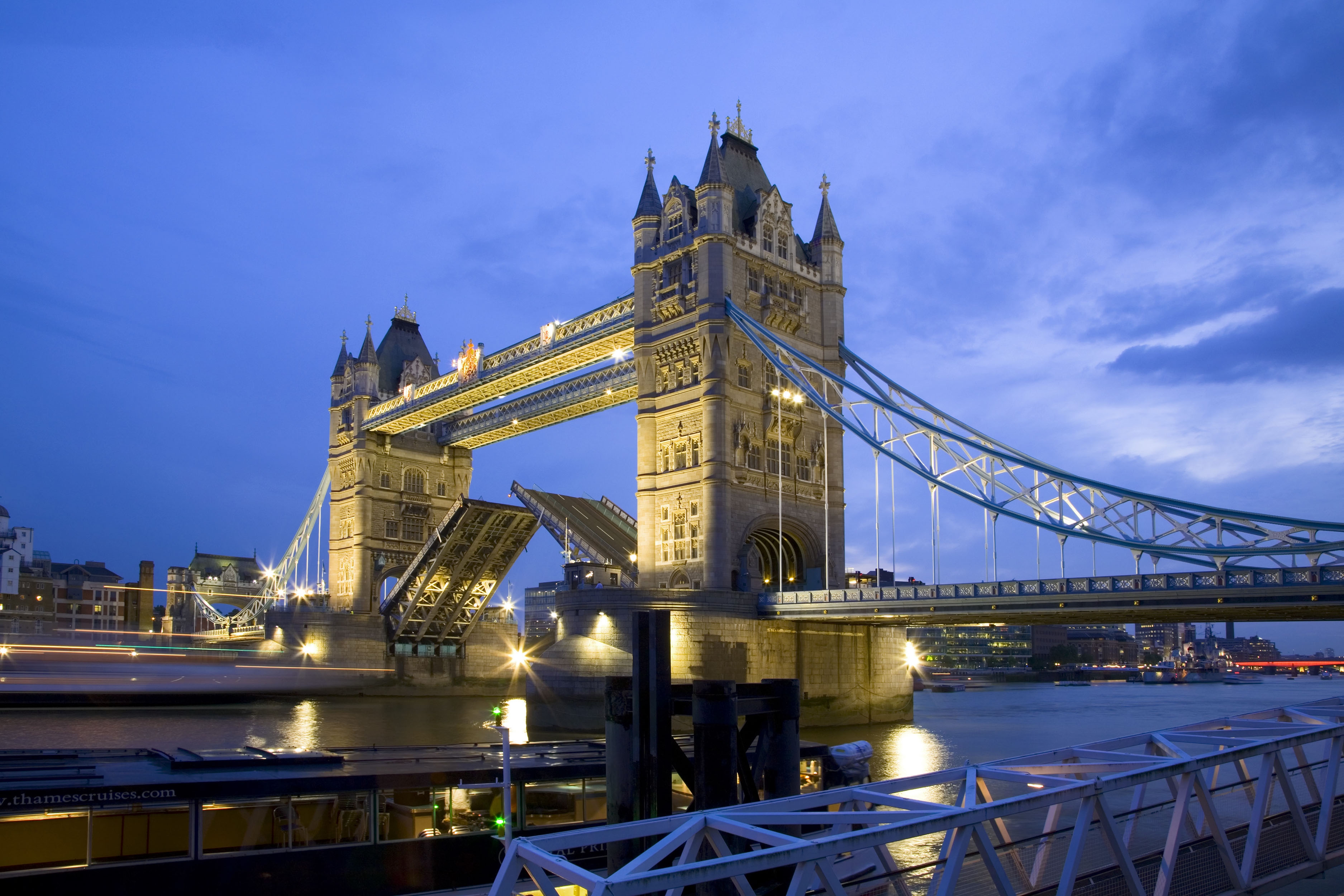 Tower Bridge opening to allow ships to pass through at dusk, viewed from the south bank of the River Thames - IGE Erlebnisreisen | Visit London